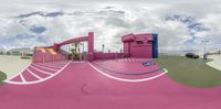 there is a 360 - cam picture taken of a pink building and car park area