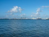 a view of ships in the harbor near a port area with cranes and cranes in the background