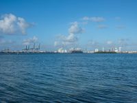 a view of ships in the harbor near a port area with cranes and cranes in the background