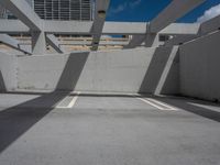 an empty parking garage with three white lines on the ground in front of a sky and city view