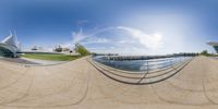 the reflection of a fish eye lens on a skateboard ramp with buildings in the background