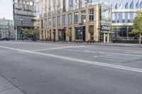 a woman with a backpack is crossing the street near buildings and cars outside a starbucks