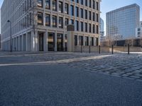 the large office building is located in the center of a cobblestone plaza of the city