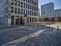 the large office building is located in the center of a cobblestone plaza of the city