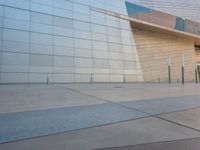 an empty building with an exterior that has glass and concrete architecture and a bench in front of the building