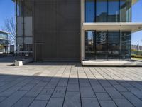 a white building with a walkway and glass windows on the side of it on a sunny day