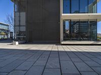 a white building with a walkway and glass windows on the side of it on a sunny day