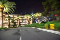 the camera lens has been blurred to see a street with palm trees and buildings behind it