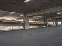 an empty parking garage with multiple parking spaces below it and a few fire escapes to the top