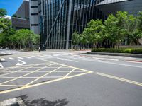 the yellow lines on the street indicate a crosswalk between a street and buildings behind