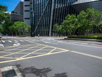 the yellow lines on the street indicate a crosswalk between a street and buildings behind