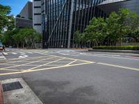 the yellow lines on the street indicate a crosswalk between a street and buildings behind