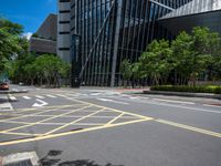 the yellow lines on the street indicate a crosswalk between a street and buildings behind