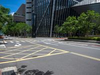 the yellow lines on the street indicate a crosswalk between a street and buildings behind