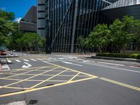 the yellow lines on the street indicate a crosswalk between a street and buildings behind