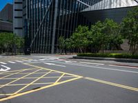 the yellow lines on the street indicate a crosswalk between a street and buildings behind