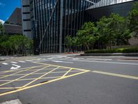 the yellow lines on the street indicate a crosswalk between a street and buildings behind