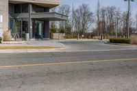 an empty road in front of a modern building on a sunny day out side the street