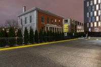 the yellow curb and red brick building are both visible in the night sky as well