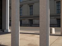 the columns in front of a building are lined with bricks and concretes, along with a long walkway