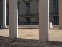 the columns in front of a building are lined with bricks and concretes, along with a long walkway