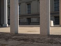 the columns in front of a building are lined with bricks and concretes, along with a long walkway