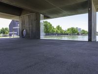 a concrete room with a circular open door and a bench in front of a pond