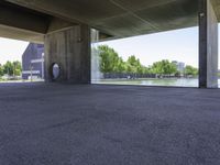 a concrete room with a circular open door and a bench in front of a pond