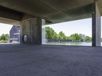 a concrete room with a circular open door and a bench in front of a pond