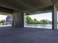 a concrete room with a circular open door and a bench in front of a pond