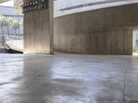 a concrete floor in the middle of an indoor parking lot with concrete railings and a clock