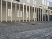 a large building with several windows in it and a street with cobblestones on the pavement