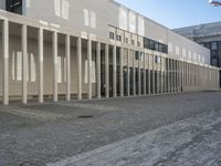 a large building with several windows in it and a street with cobblestones on the pavement