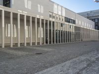 a large building with several windows in it and a street with cobblestones on the pavement