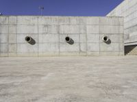 a big building that has lots of concrete around it with three large holes that have been cut out