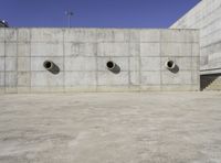 a big building that has lots of concrete around it with three large holes that have been cut out