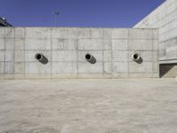 a big building that has lots of concrete around it with three large holes that have been cut out