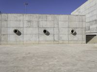 a big building that has lots of concrete around it with three large holes that have been cut out