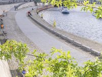 people riding bikes by the river while walking on it's side in the day