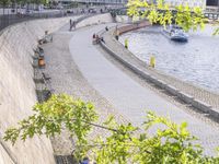 people riding bikes by the river while walking on it's side in the day