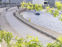 people riding bikes by the river while walking on it's side in the day