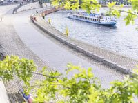 people riding bikes by the river while walking on it's side in the day