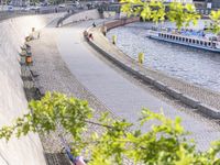 people riding bikes by the river while walking on it's side in the day