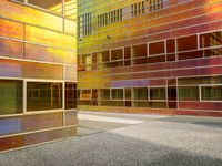 the building is reflecting a very modern looking area of light in the foreground are various colored glass and metal