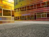 the building is reflecting a very modern looking area of light in the foreground are various colored glass and metal