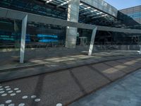 a sidewalk next to a road and a building with many windows and some columns and a walkway covered in polka dots