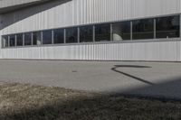 a stop sign on the side of the road next to an empty parking lot and an industrial building