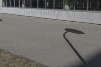 a stop sign on the side of the road next to an empty parking lot and an industrial building