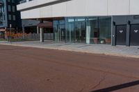 a large white building with many windows near the street side of it on a sunny day