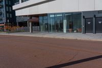 a large white building with many windows near the street side of it on a sunny day